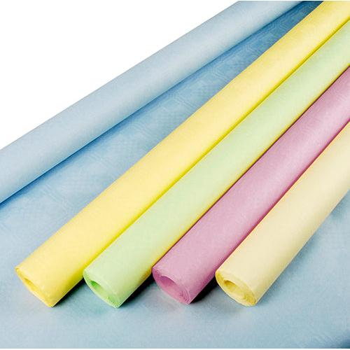 Eine Rolle PAPSTAR Papiertischtuch mit Damastprägung 8 m x 1 m farbig sortiert von der PAPSTAR GmbH wird ausgerollt, um ihre weiche, farbenfrohe Textur zu präsentieren, angeordnet auf einem Blatt hellblauem Seidenpapier.