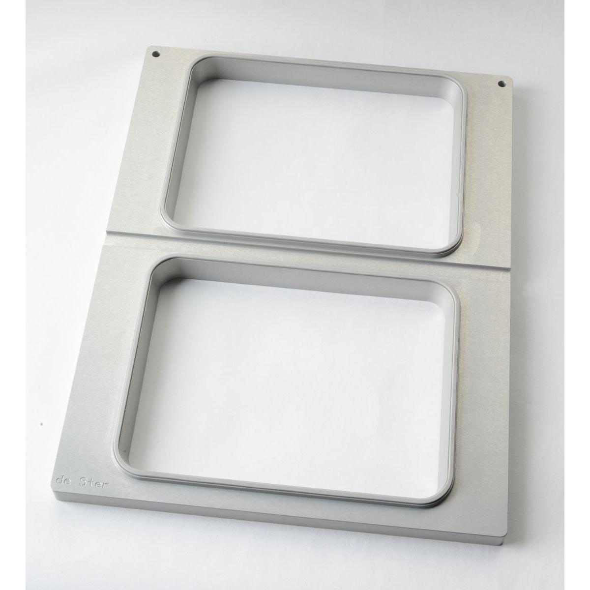 Die Kassette DF15/25 f. CPET Schalen 960, 1200, 1500 ml (2-nutzig) von Duni GmbH ist ein rechteckiger Metallrahmen mit zwei großen, abgerundeten, rechteckigen Öffnungen, zwei kleinen Löchern in der oberen Ecke und einem eingravierten Text in der unteren linken Ecke.