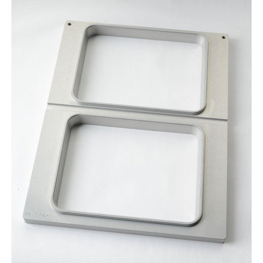 Die Kassette DF15/25 f. CPET Schalen 960, 1200, 1500 ml (2-nutzig) von Duni GmbH ist ein rechteckiger Metallrahmen mit zwei großen, abgerundeten, rechteckigen Öffnungen, zwei kleinen Löchern in der oberen Ecke und einem eingravierten Text in der unteren linken Ecke.