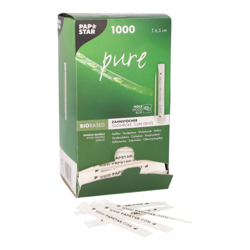 Ein grüner PAPSTAR Spenderkarton mit der Aufschrift „pure“ fasst 1.000 einzeln verpackte Holzzahnstocher (6,5 cm). Unten offen, ragen mehrere weiß verpackte Stäbchen heraus. Marke: PAPSTAR GmbH.