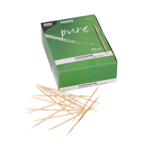 Eine grün-weiße PAPSTAR „pure“-Box mit der Aufschrift „Zahnstocher Holz rund 8 cm (1000 Stück)“ der PAPSTAR GmbH steht davor, davor liegen verstreut mehrere umweltfreundliche Zahnstocher aus Holz.