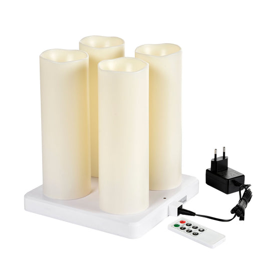 Das Duni GmbH LED-Stumpenkerzen-Set (4 x 220x75mm, warmweiß, bis zu 12h Brenndauer) steht auf einer weißen rechteckigen Ladestation; Fernbedienung und schwarzes EU-Netzteil liegen daneben.