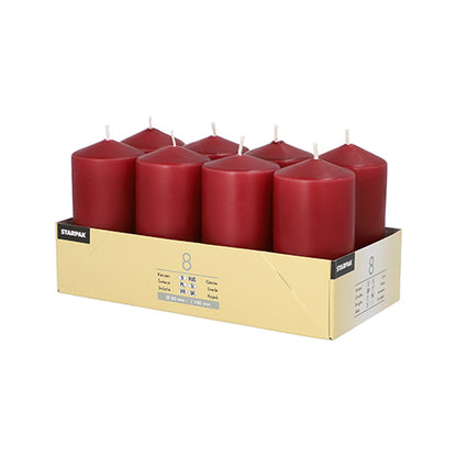 A cardboard tray contains 8 upright red Starpak pillar candles (Ø 50 mm · 100 mm) made from high-quality wax, arranged in two rows. The tray shows product and quantity details – perfect for a cozy atmosphere.