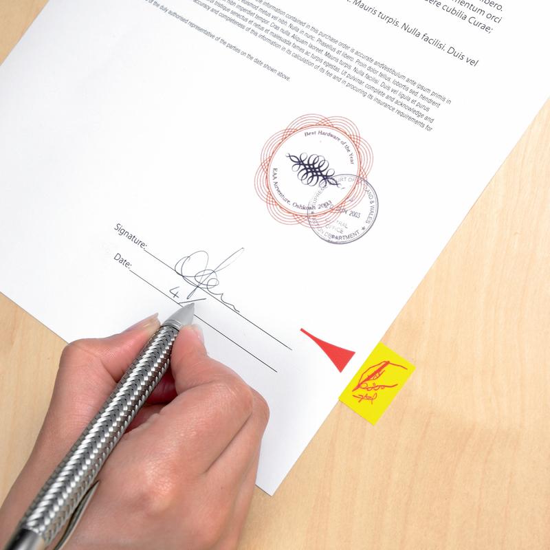 A hand signs a document on wood that is marked with a Post-it® Index Tab, Standard, Yellow (25.4 mm x 43.2 mm) from 3M Deutschland GmbH. The paper features official stamps, a signature line, a date field, and a yellow tab with a red arrow.