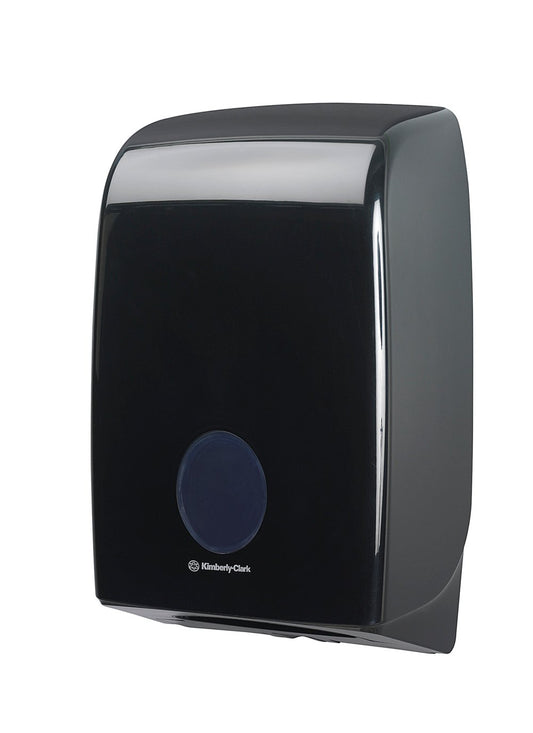 Der schwarze Aquarius™ Spender für gefaltete Handtücher (Interfold) von Kimberly-Clark GmbH verfügt über eine runde Frontöffnung und ein Logo darunter und ist für die Wandmontage vorgesehen. 1 Spender pro Karton, abgebildet auf weißem Hintergrund.