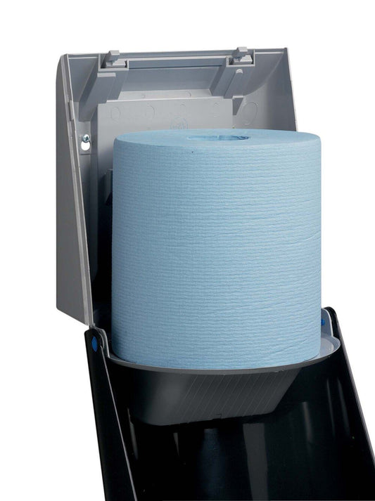 Eine blaue Papierhandtuchrolle wird in eine graue Kimberly-Clark Professional™ Wischtuch-Spender-Zentralentnahme (1 Spender, Grau) der Kimberly-Clark GmbH eingelegt, wobei der Deckel zur hygienischen Entnahme über die praktische Zentralentnahme geöffnet ist.