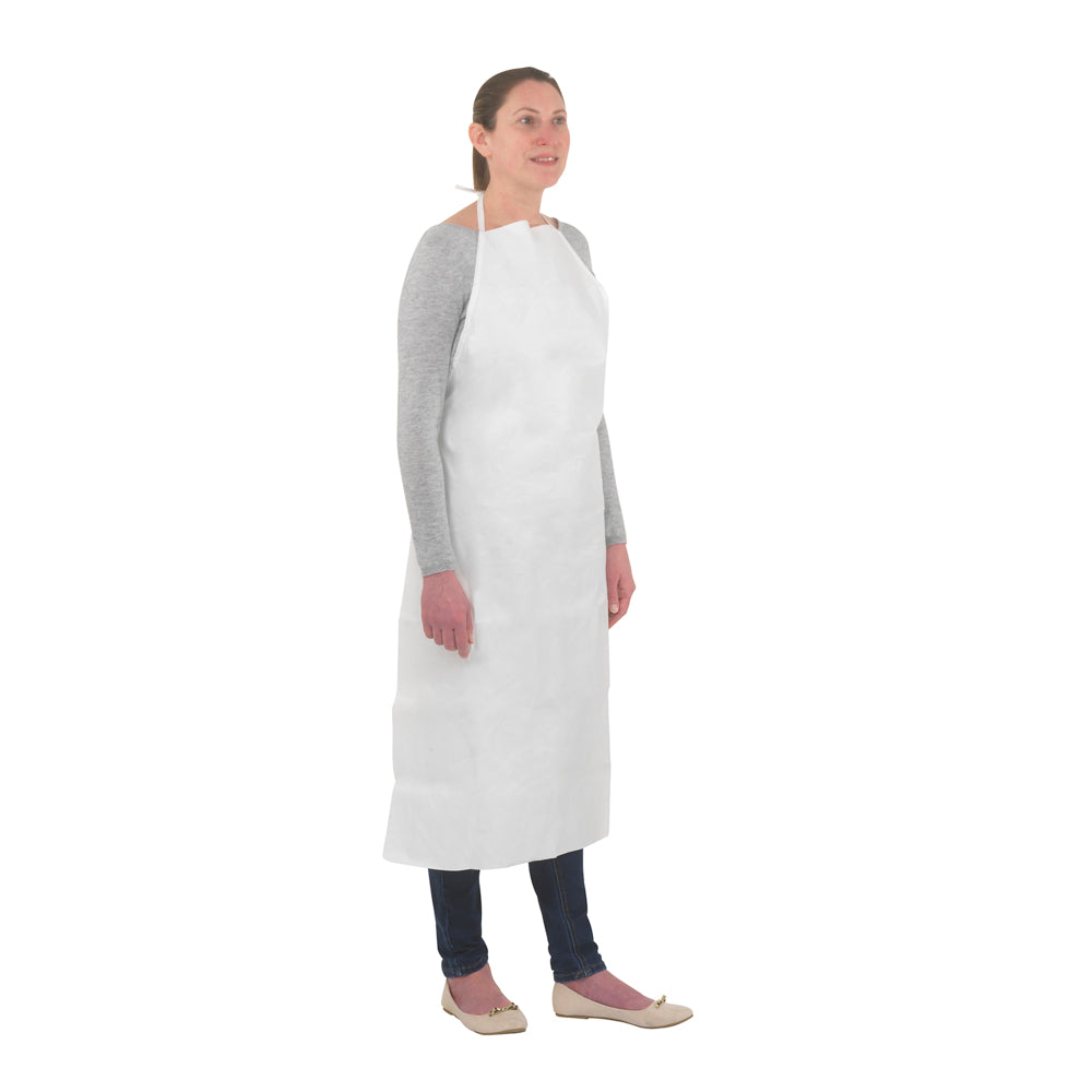 Eine Person steht vor einem einfarbig weißen Hintergrund und trägt eine Kimberly-Clark GmbH KleenGuard® A40 Leichte Kurzschürze (weiß) über einem grauen langärmeligen Hemd und einer dunklen Hose.