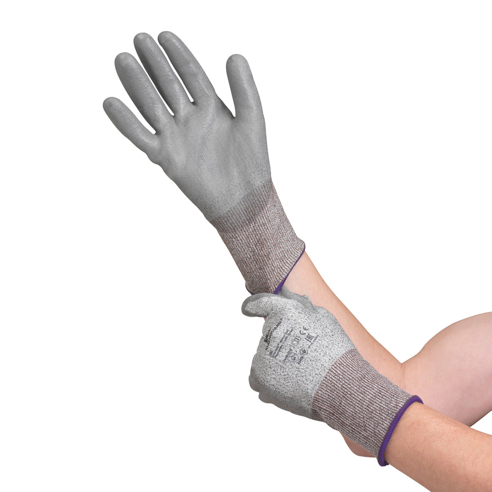 Eine Person zieht den grauen, handtypischen KleenGuard® G60 Endurapro™ Schnittfeste Handschuhe Level 3 von Kimberly-Clark GmbH an und zieht mit der anderen Hand den Handschuh mit dunklerer Stulpe über das Handgelenk.