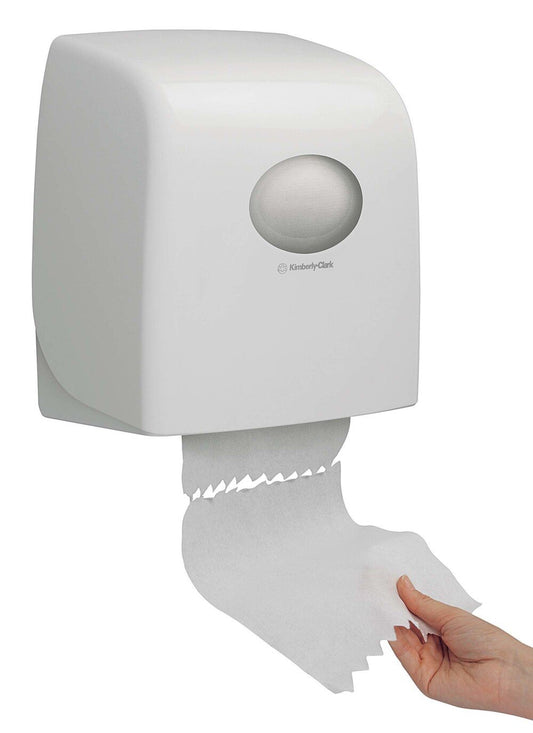 Eine Hand spendet Papierhandtücher aus einem weißen, an der Wand montierten Aquarius™ Slimroll™ Rollenhandtuchspender der Kimberly-Clark GmbH, der eine sichtbare Rolle im Inneren hat.