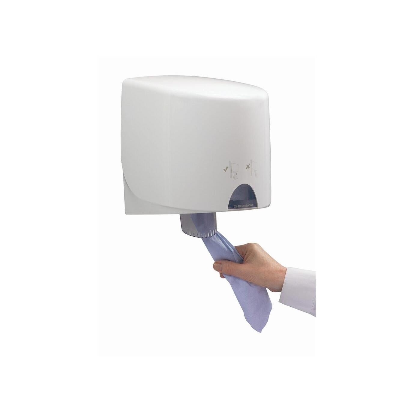 A person pulls a blue WypAll® L10 paper wipe from Kimberly-Clark GmbH from a wall-mounted white dispenser with hygiene instructions above the opening - ideal for food areas.