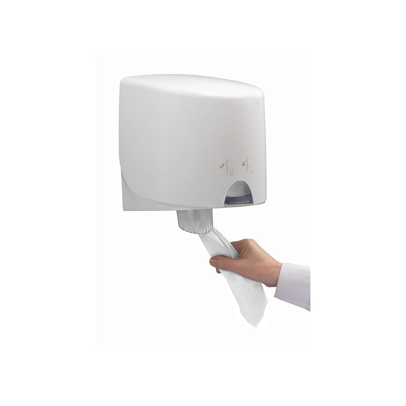 Eine Hand zieht ein WypAll® L10 Papierwischtuch für Lebensmittel & Hygiene aus einem weißen, wandmontierten Spender der Kimberly-Clark GmbH mit Zentralentnahme vor einem unifarbenen Hintergrund.