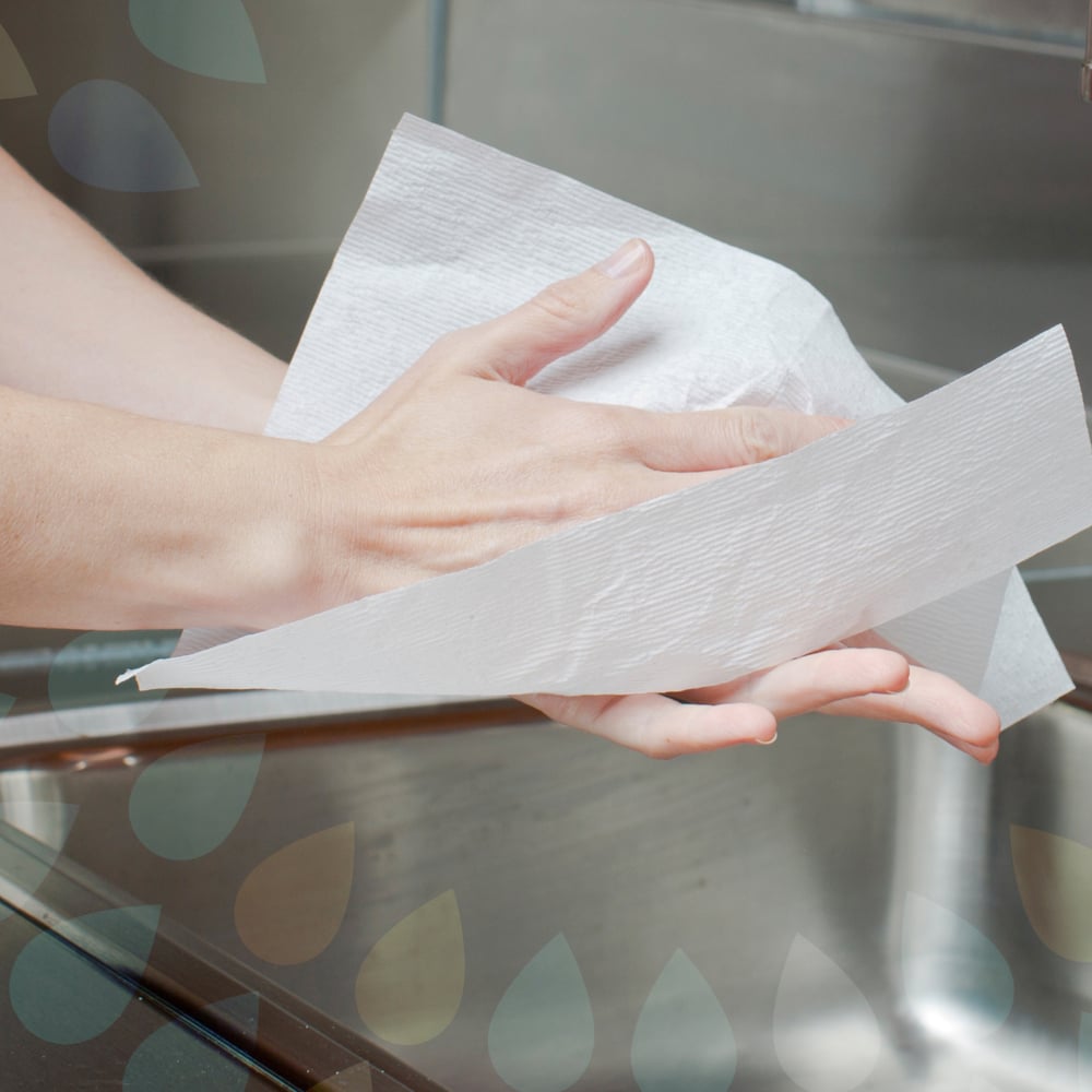 Eine Person trocknet ihre Hände mit Kleenex® Ultra™ Handtüchern (Interfold, Weiß, Groß, 30 x 94 Blatt) von Kimberly-Clark GmbH über einem Edelstahlspülbecken.