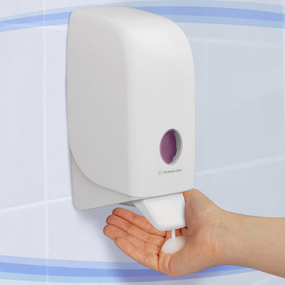 A person dispenses foam soap from a white Aquarius™ dispenser for wash lotions - cassette / 1 Ltr from Kimberly-Clark GmbH onto their hand in a tiled bathroom.