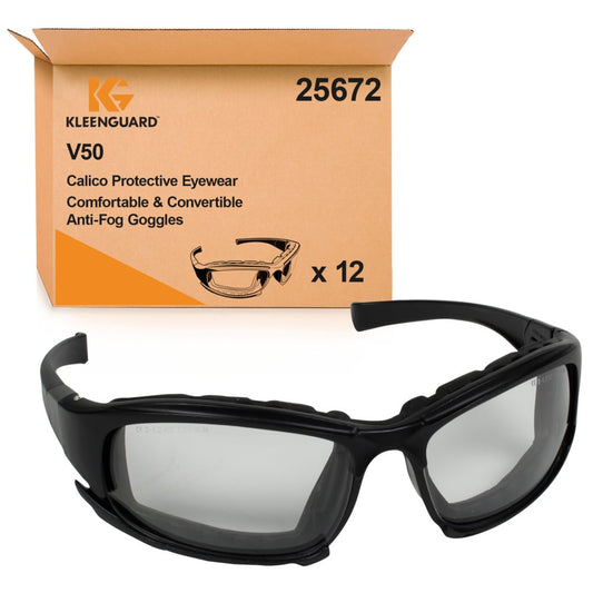 Eine schwarze KleenGuard® V50 Calico™ Schutzbrille mit beschlagfreien, transparenten Gläsern steht vor einer braunen Schachtel der Kimberly-Clark GmbH mit der Aufschrift "1 Karton x 12 Brillen" und einer Produktinformation sowie einer Abbildung einer Schutzbrille.