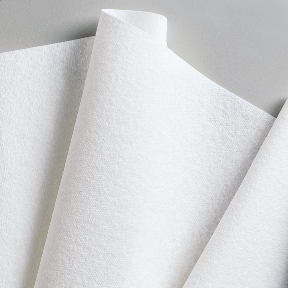 Nahaufnahme von überlappenden Kimberly-Clark GmbH WypAll® L40 PowerClean Viertelgefaltete Papierhandtücher (weiß, 18 Packungen x 56 Blatt), schräg angeordnet vor einem neutralen Hintergrund.