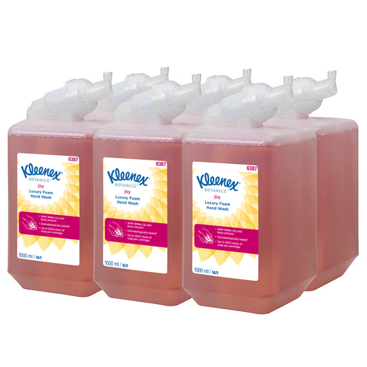 Sechs 1-Liter-Kassetten Kleenex® Botanics™ Luxury Foam Hand Wash von Kimberly-Clark GmbH, jeweils gefüllt mit roter Flüssigkeit und pflanzlichen Inhaltsstoffen, sind übersichtlich in zwei Dreierreihen angeordnet. Jede Kartusche spendet Schaum und wird in einer Schachtel mit sechs Stück geliefert.