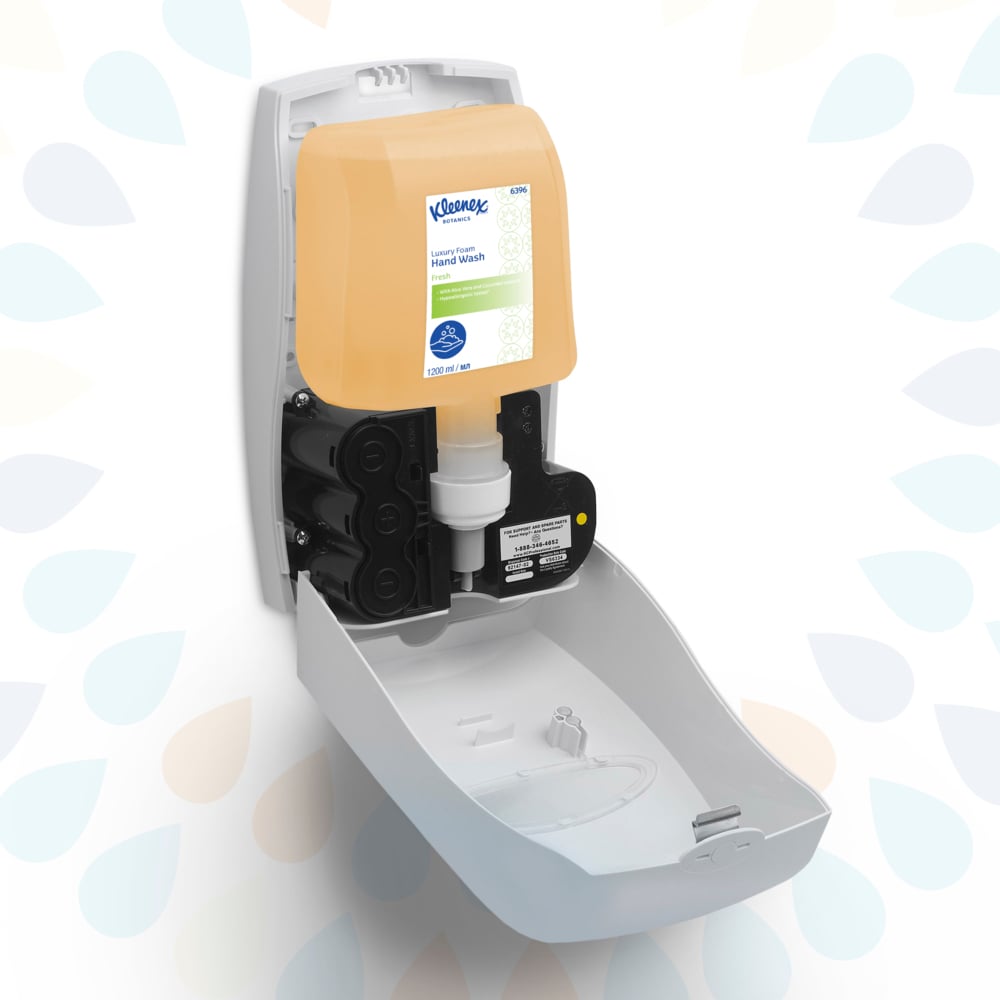 Ein weißer, an der Wand montierter Spender ist mit geöffneter Vorderseite zu sehen, die eine 1,2 l fassende Kleenex® Botanics™ Luxury Foam Hand Wash-Kassette der Kimberly-Clark GmbH zeigt; die durchsichtige beigefarbene Kartusche passt genau hinein.
