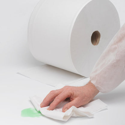 A hand wipes a green stain with absorbent paper, while in the background a WypAll® L20 General Clean large roll (2 rolls x 1085 sheets) from Kimberly-Clark GmbH lies on a white surface, ready for tough cleaning tasks.