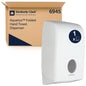 A white Aquarius™ dispenser for folded towels from Kimberly-Clark GmbH stands next to a brown box labeled "6945". The dispenser has a round window that ensures hygienic towel dispensing. 1 dispenser per carton.
