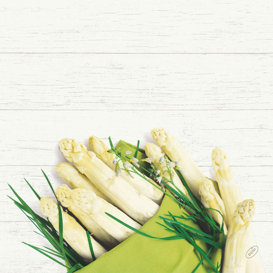Ein Bündel weißer Spargel und grüner Kräuter ruht auf einer 40x40cm Bio-Dunisoft-Serviette der Duni GmbH vor einem weißen Holzhintergrund.
