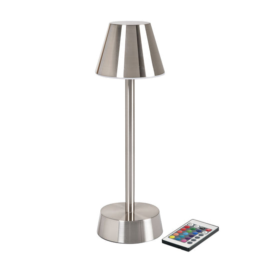Die ZELDA silber kabellose LED-Lampe von Duni GmbH zeichnet sich durch eine metallische Oberfläche, einen konischen Schirm, einen zylindrischen Schaft und einen runden Sockel aus, der neben einer rechteckigen Fernbedienung mit farbigen Tasten für energiesparende Beleuchtung gezeigt wird.