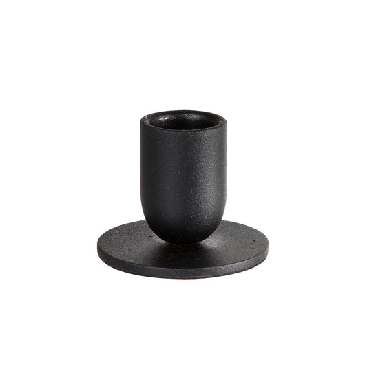 Der Duni GmbH Kerzenhalter Metall, 5,7x4,3cm Totem (1 Stück) in schwarz hat eine zylindrische Form mit einem abgerundeten Fuß auf einer flachen runden Platte und bietet zeitloses Design und elegantes Wohnaccessoires-Flair auf weißem Hintergrund.