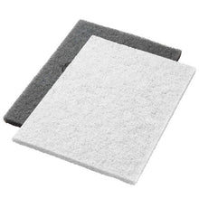 Zwei Twister Pads 14x20" Weiß (35x51 cm) von Diversey Deutschland GmbH & Co. OHG, Arbeitsschritt 1, liegen flach auf weißem Hintergrund: das weiße Pad oben, leicht überlappend auf einem dunkelgrauen Pad. Ideal für professionelle Anwendungen.