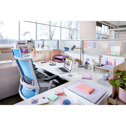 A modern office workspace with white desks, blue chairs, laptops, office supplies, potted plants, and natural light features Post-it® Super Sticky Notes (76 mm x 127 mm, 90 sheets/block, 100% PEFC) from 3M Deutschland GmbH.