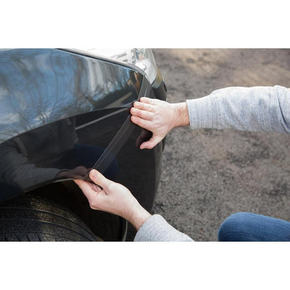 A person applies the Scotch® Extremium™ No Residue High Performance Duct Tape (18.2 m x 48 mm) from 3M to the front fender edge of the car and presses it onto the paint to protect the surface without leaving residues.