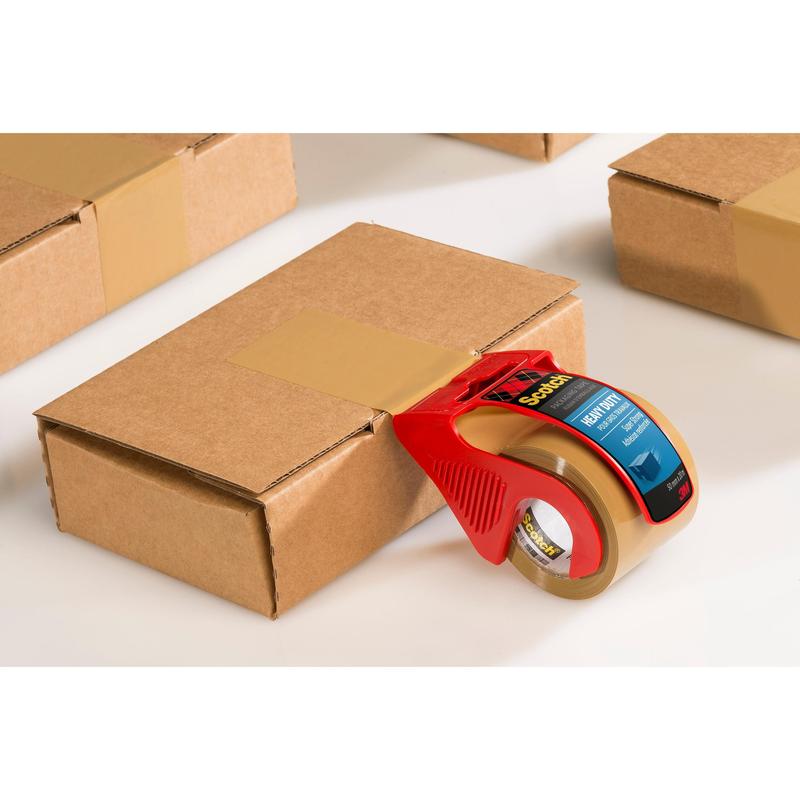 A Scotch® Extra strong packaging tape, brown (48 mm x 20.3 m) from 3M Deutschland GmbH in the red hand dispenser seals a box; additional sealed boxes lie next to it on a white background.