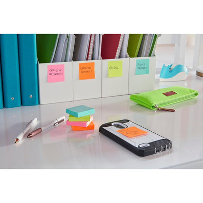 On the tidy desk are labeled folders, a green pencil case, two pens, and a smartphone with a Post-it® Super Sticky Note (76x127 mm, 3M Deutschland GmbH), on which "AM Call Client Chet" is written. The well-lit surface is white.