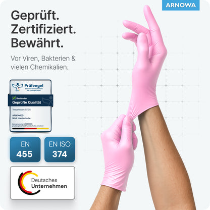 Eine Person trägt ARNOMED NITRIL BLOSSOM ROSE Einmalhandschuhe aus Nitril Rosa von ARNOWA GmbH, zertifiziert als latexfrei und schützend gegen Viren, Bakterien und Chemikalien; es sind die Logos EN 455 und EN ISO 374 sowie ein deutsches Firmenemblem abgebildet.