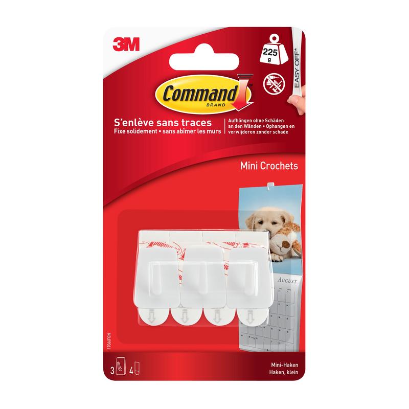 A pack of Command™ Mini-Hooks, 17066 by 3M Deutschland GmbH, contains three white adhesive hooks with French and English labels - ideal for small spaces - and shows a dog and a calendar in the background.