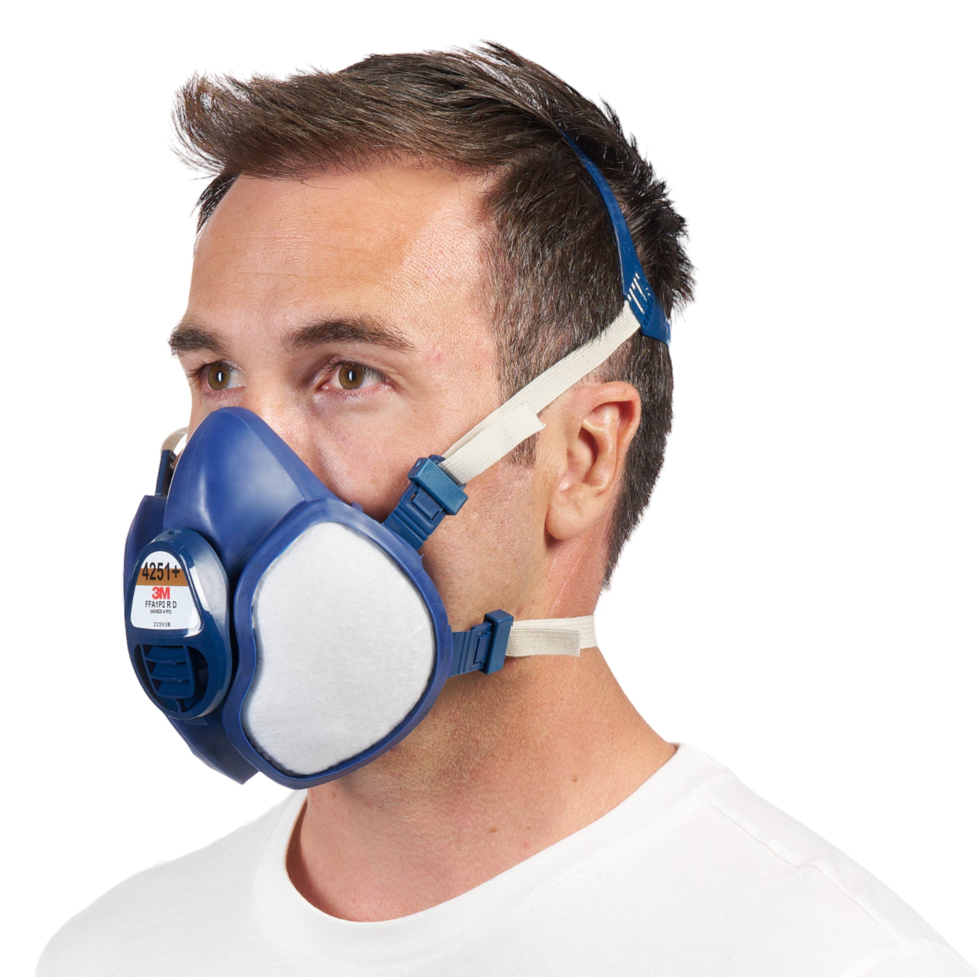 Ein Mann im Profil trägt die 3M™ Atemschutzmaske mit integrierten Filtern der 3M Deutschland GmbH in den Farben Blau und Weiß mit verstellbaren Kopfbändern vor einem schlichten weißen Hintergrund.