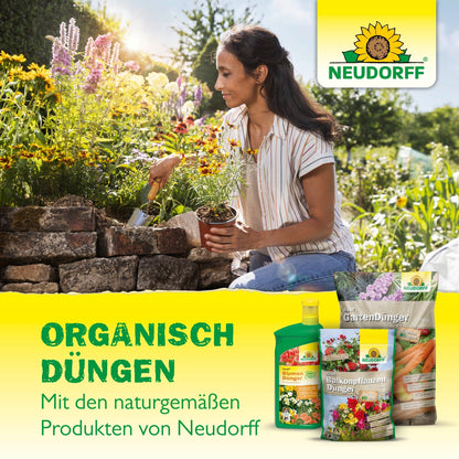 A woman is gardening next to a stone planter, holding a potted plant and a trowel. In the foreground, Neudorff Shop Azet Tomato Fertilizer products are visible, with German text highlighting organic complete fertilizer for a rich harvest.
