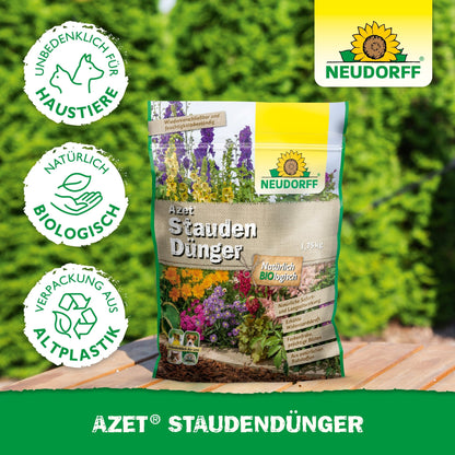 A bag of Neudorff Shop Azet Perennial Fertilizer, an organic, pet-safe fertilizer made from recycled plastic, lies outdoors on wood with blurred green foliage - ideal for healthy perennials and gardens.