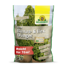 A 1.75 kg bag of Neudorff Shop Azet Buxus & Ilex Fertilizer stands upright and shows green boxwood and holly on the packaging, with product information and a reach of 70 m² printed on the front.