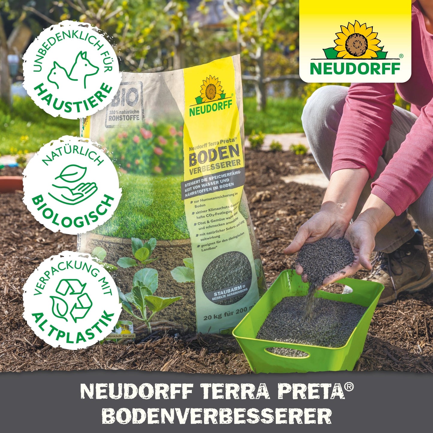 In a garden, the Neudorff Terra Preta Soil Improver from Neudorff Shop is applied with a green shovel into the soil next to the leafy plants. The upright standing bag displays symbols for pet safety, organic content, and recycled packaging.