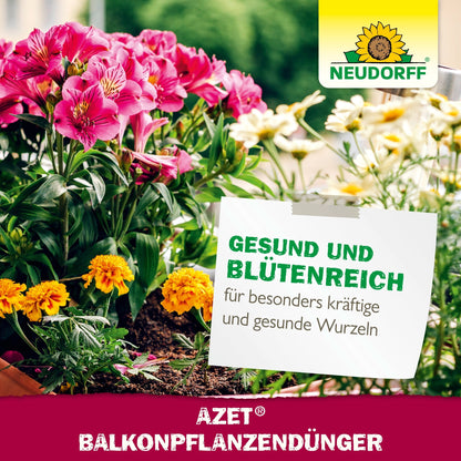 Pictured is a flower box with pink and yellow summer flowers. A sign advertises Neudorff Shop Azet Liquid Balcony Plant Fertilizer for healthy blooms in window boxes. The Neudorff logo is shown at the top right.