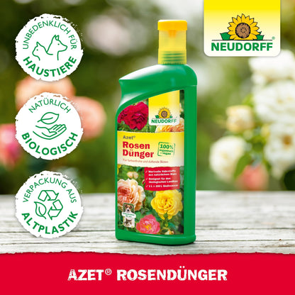 A green bottle of Azet Liquid Rose Fertilizer from Neudorff Shop stands on a wooden surface. The label shows bright roses, with symbols for pet safety, organic quality, and packaging made from bioplastic. The Neudorff logo appears at the top right.