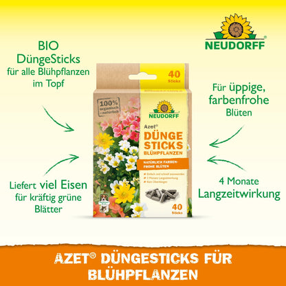 A box of Neudorff Shop Azet Fertilizer Sticks for flowering plants is shown among flowers, with notes on the 4-month effect, iron supply, organic content, and optimal nutrition for vibrant blooms.