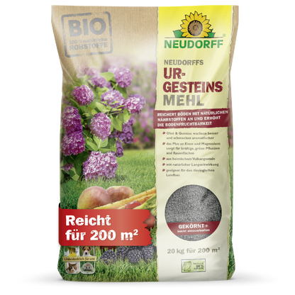 A 20 kg bag of Neudorff's UrgesteinsMehl from the Neudorff Shop, depicted with purple flowers, carrots, and soil images. The bag with German text covers 200 m² and contains mineral powder for use in the soil.