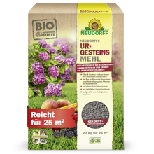 A box of Neudorff's UrgesteinsMehl from the Neudorff Shop stands upright and displays pictures of hydrangeas, apples, and grass. The 2.5 kg package is sufficient for 25 m² and is intended to improve soil fertility.