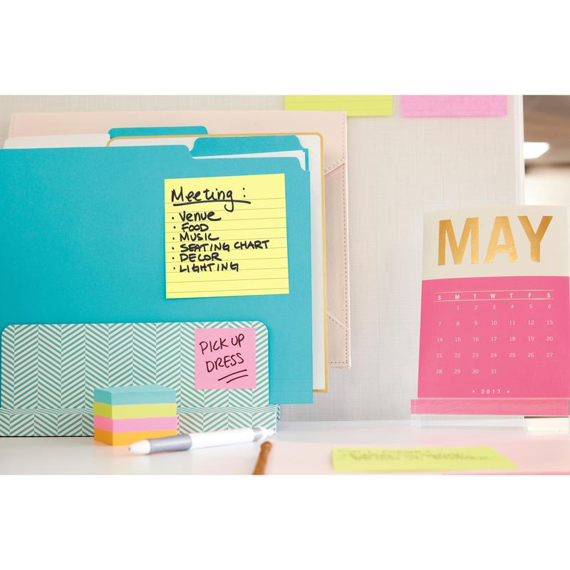 A desk with colorful folders, a stack of sticky notes, and a pink-gold calendar for May 2017. On the Post-it® Super Sticky Notes (101 mm x 101 mm, 90 sheets, PEFC) from 3M Deutschland GmbH are meeting topics and "PICK UP DRESS.