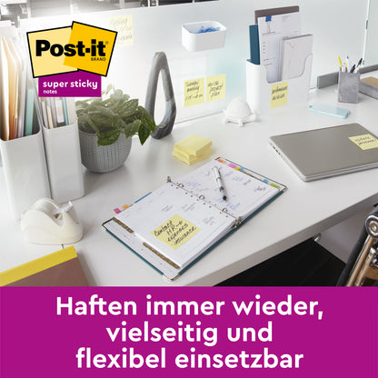 A tidy office desk with a laptop, planner, and 3M Deutschland GmbH Post-it® Super Sticky Notes, Yellow, 76 mm x 76 mm (90 sheets/pad, 14+2 pads/package), on various surfaces. Text: "Sticks repeatedly, versatile and flexible to use."