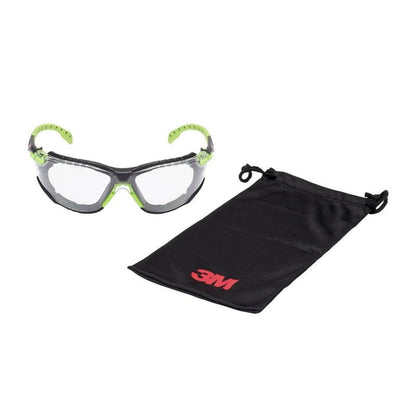 The 3M™ Solus™ Safety Glasses 1000 with clear lenses and green-black frame is shown next to a black drawstring pouch with a red 3M logo. Includes Scotchgard™ Anti-Fog Coating and attachable foam gasket.