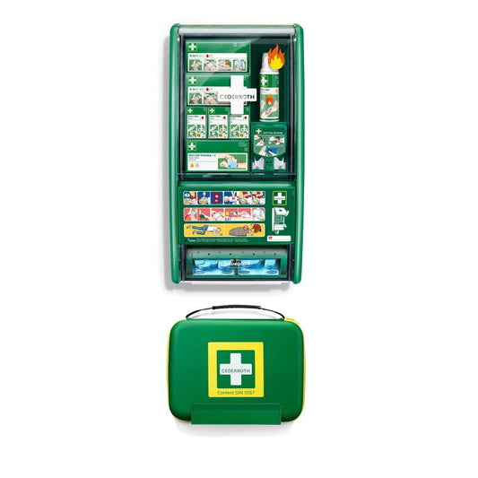 Ein grünes Orkla Wound Care AB Cederroth First Aid & Burn Station Set DIN 13157 (91 Teile, 22,7 x 29,4 x 57,2 cm) ist an der Wand montiert und enthält Zubehör und eine bebilderte Anleitung. Darunter befindet sich ein grüner Cederroth-Verbandskasten mit einem gelben Griff.