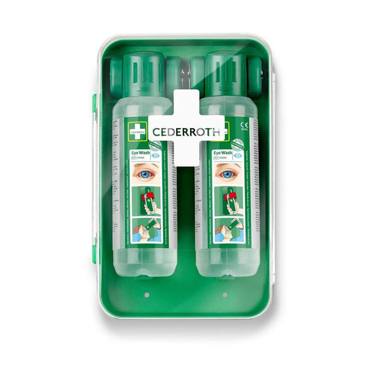 Der Cederroth Augenspülschrank 1x1 von Orkla Wound Care AB ist ein grüner Wandschrank, der zwei durchsichtige Augenspülflaschen mit grünen Kappen, eine Gebrauchsanweisung und einen weißen Deckel mit einer kreuzförmigen Erste-Hilfe-Ausrüstung für Augenspülungen enthält.