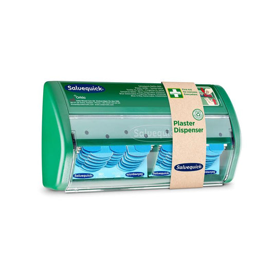 Ein Salvequick-Pflasterspender von Orkla Wound Care AB hat eine transparente Vorderseite und spendet blaue, detektierbare Pflaster; ein braunes Papierband kennzeichnet ihn als Pflasterspender".