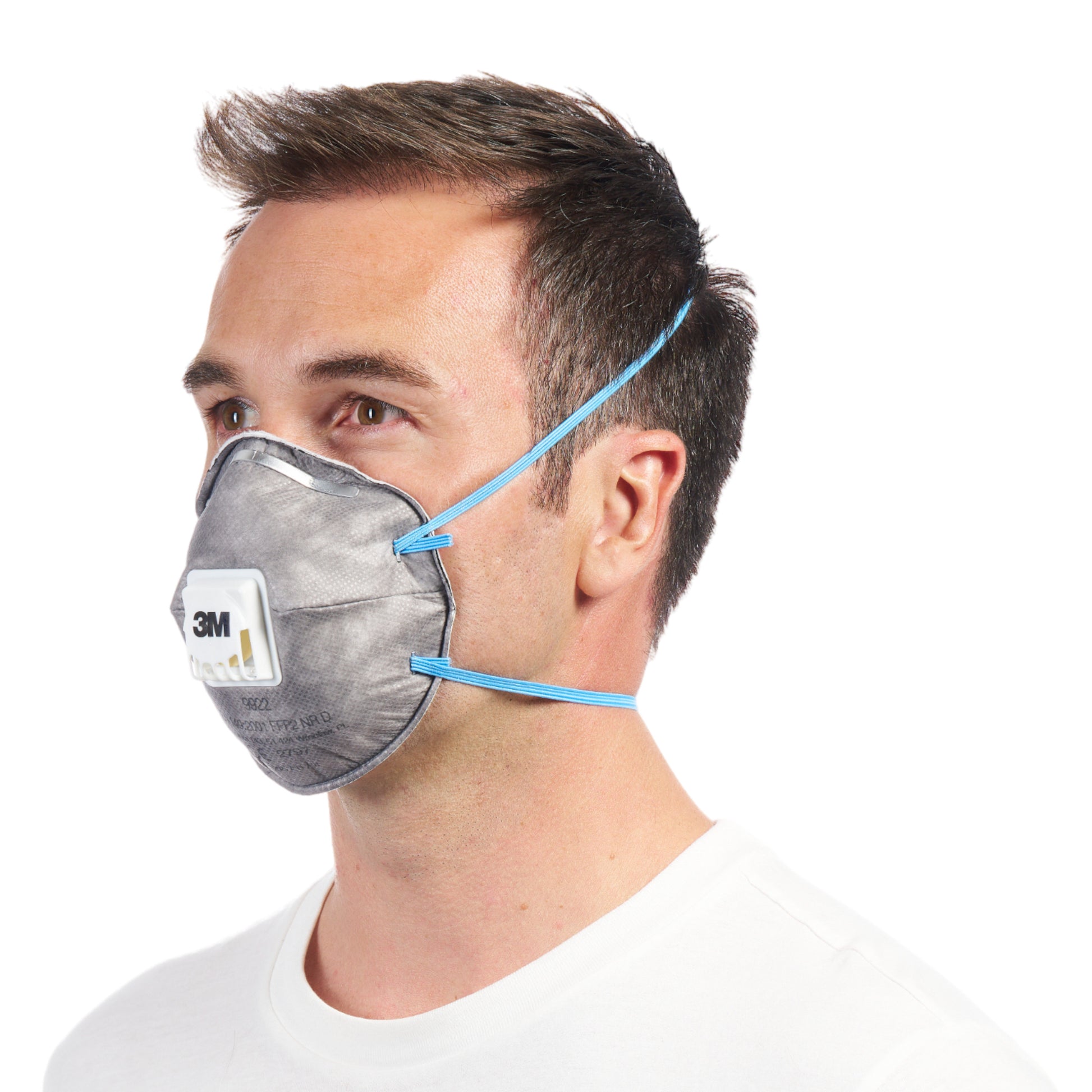 Eine Person mit kurzen braunen Haaren und weißem Hemd trägt in der Seitenansicht eine 3M™ Cool Flow™ Partikelmaske 9922 FFP2 mit blauen Gurten und Ventil der 3M Deutschland GmbH.